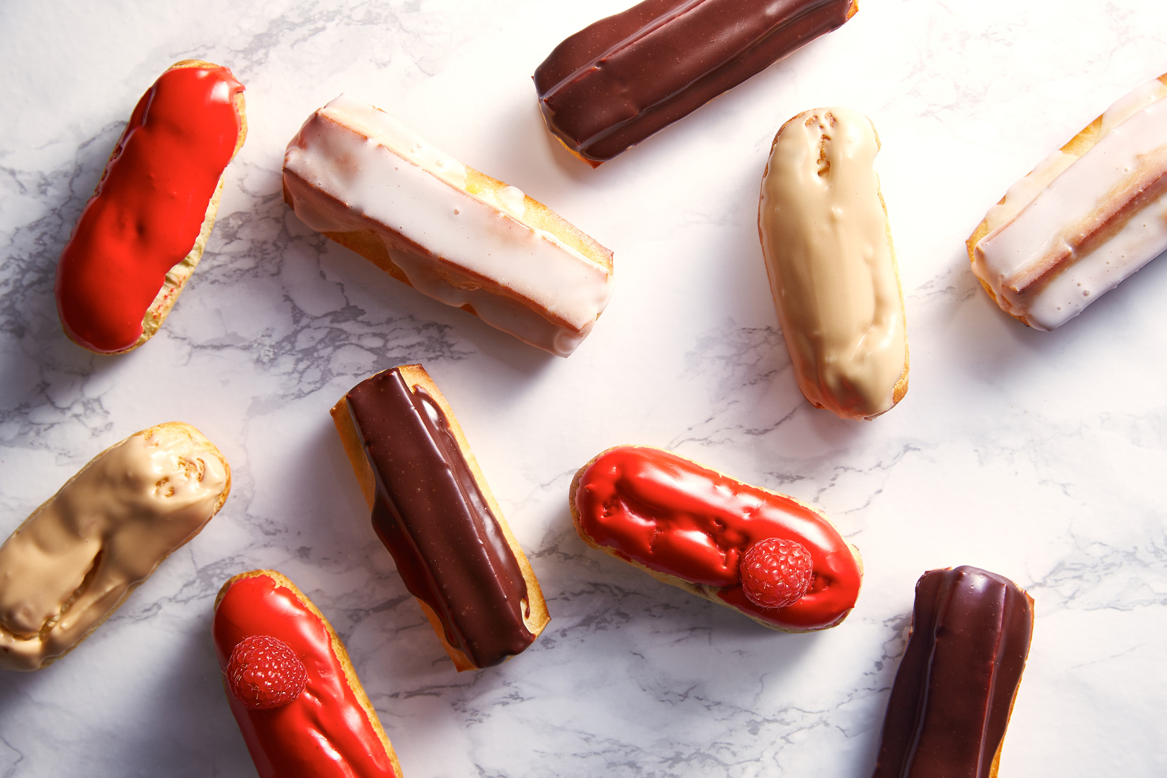 Variety of eclairs on marble background