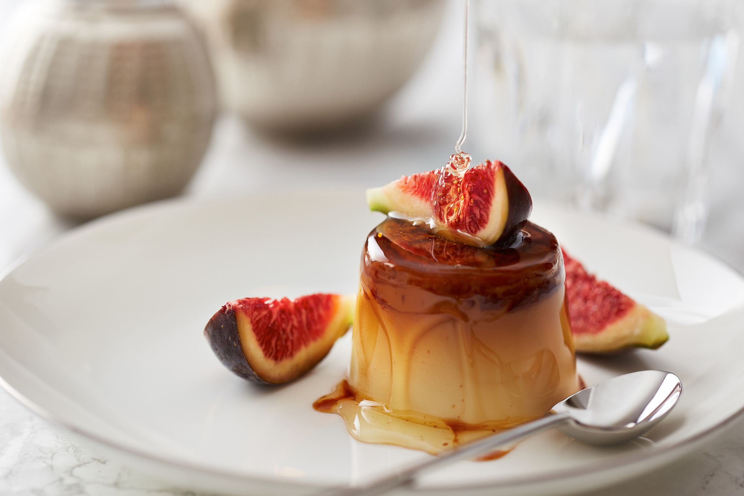 Pouring honey on fig and pudding